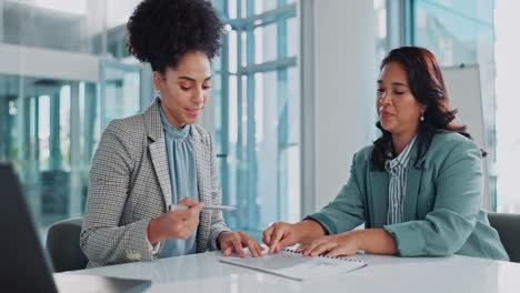 two businesswomen in a meeting discussing a contract