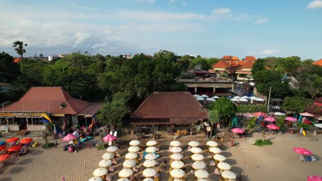 rows of sun parasols at double six beach in seminyak bali indonesia - aerial flyover