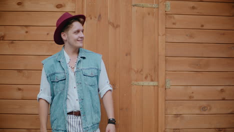 man in stylish outfit against a wooden wall