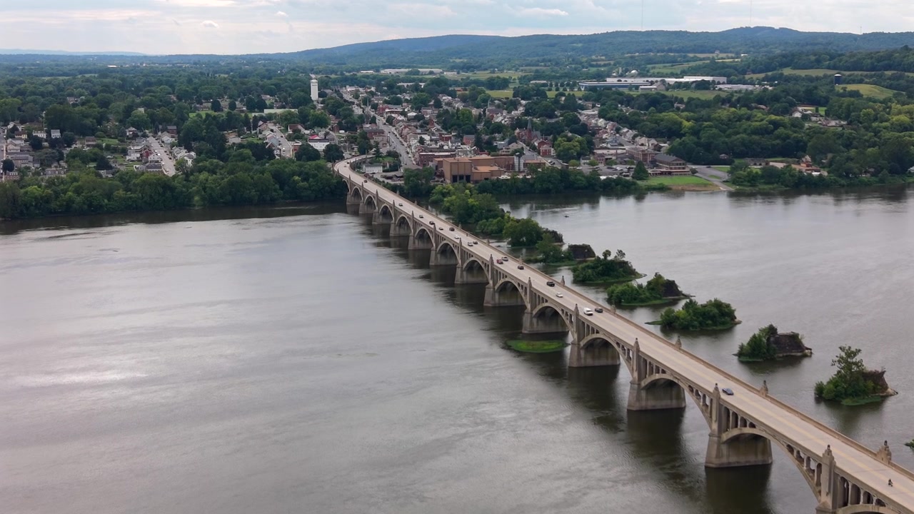 Una ripresa aerea con drone che cattura lo storico ponte ad arco in cemento Veterans Memorial Bridge che attraversa l'ampio fiume Susquehanna tra Wrightsville e Columbia, Pennsylvania