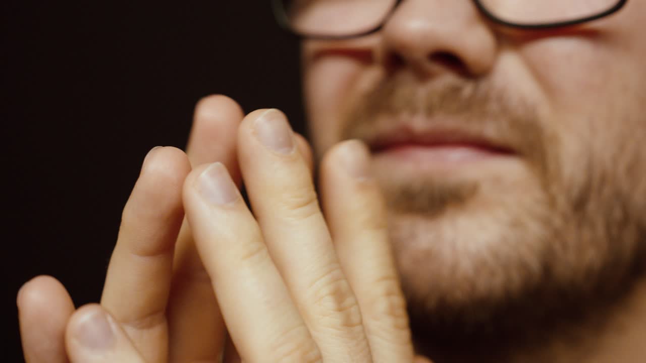 Primo piano di un uomo che muove pensosamente le dita mentre pensa. Concetto di processo decisionale, esitazione, stress, contemplazione e processo mentale