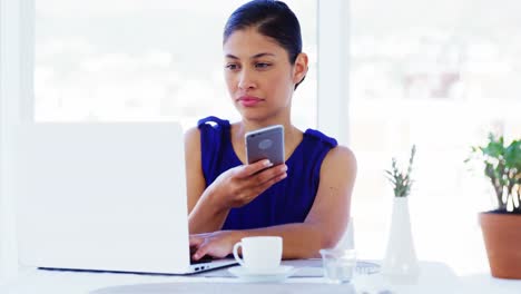 Mujer-Llamando-Por-Teléfono-Inteligente-En-La-Oficina