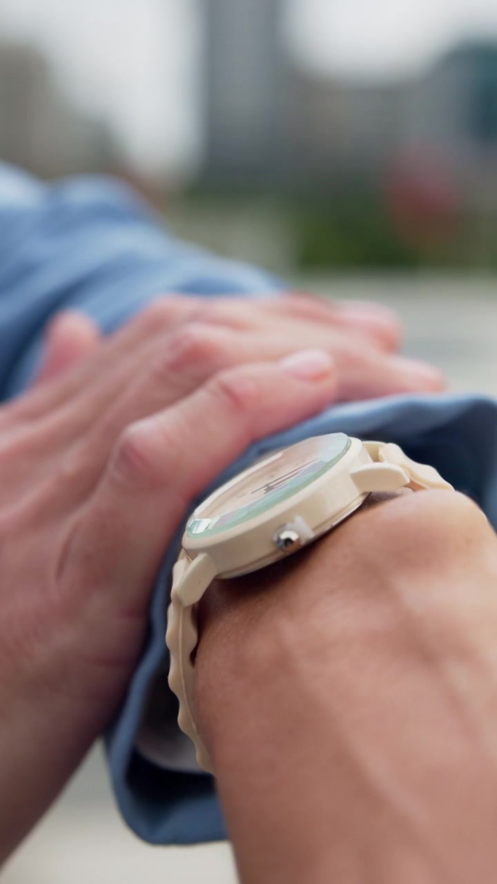 Person Checking Time on Wristwatch Outdoors