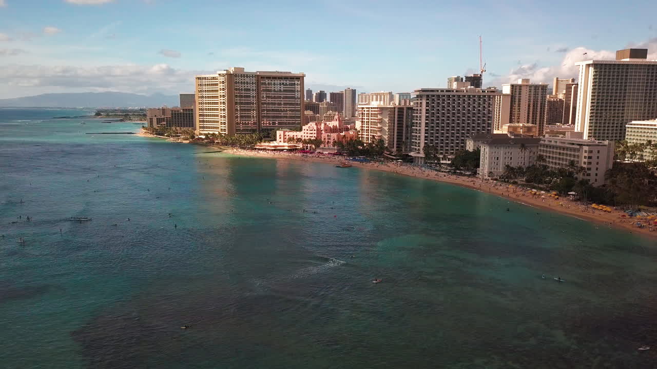해가 뜨는 하와이 오아후 의 와이키키 해변 과 호놀 ⁇ 루 도시 와 함께 서퍼 들 의 공중 촬영