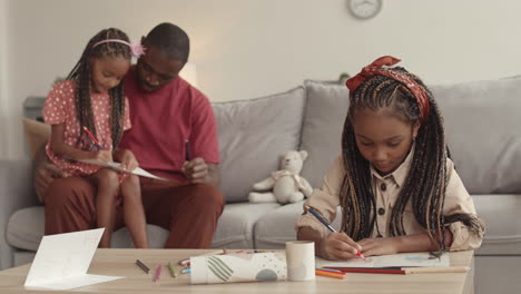 african girl drawing and family sitting