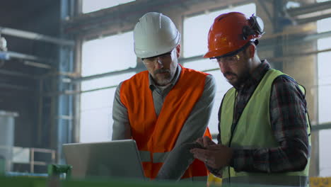 factory engineers reviewing project on laptop