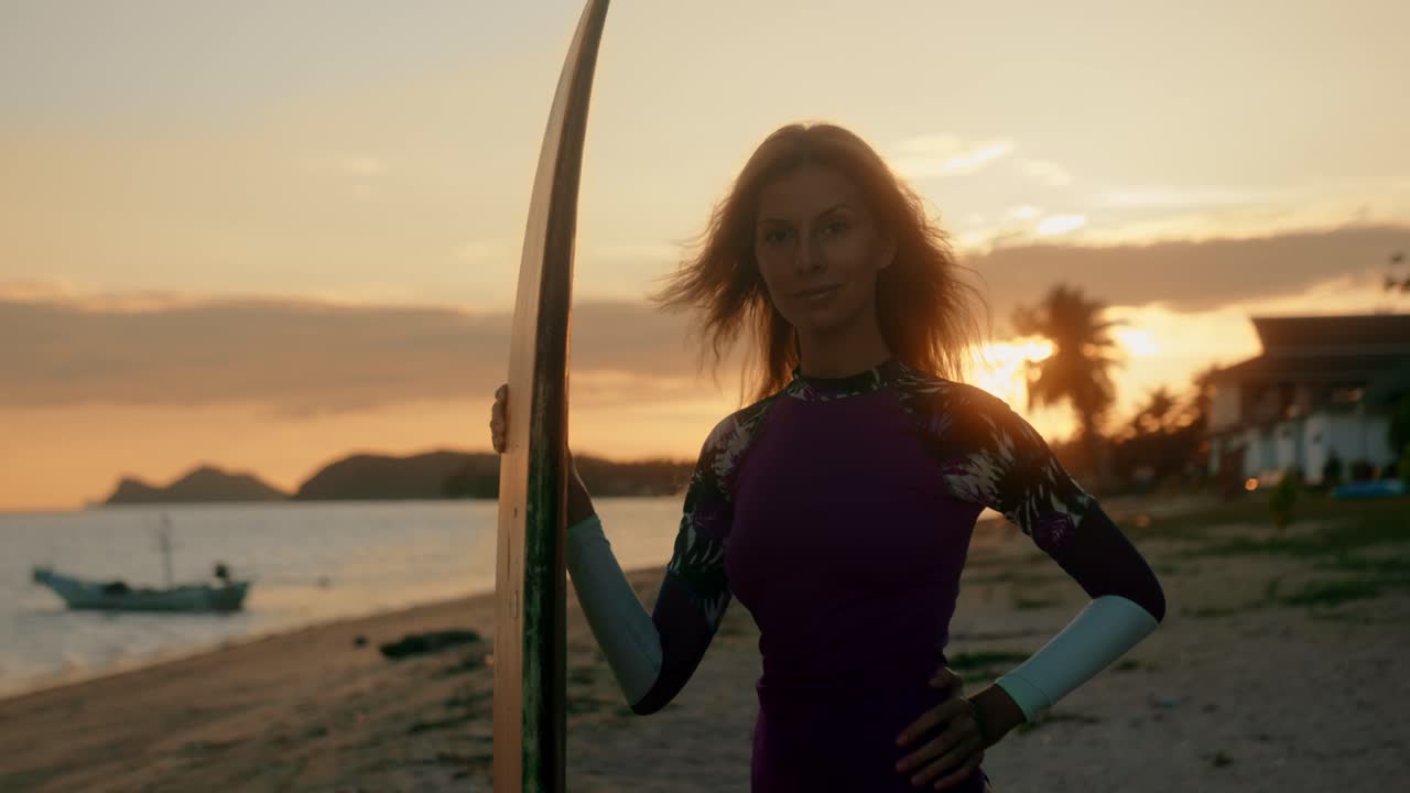 Woman with Surfboard at Sunset on Beach