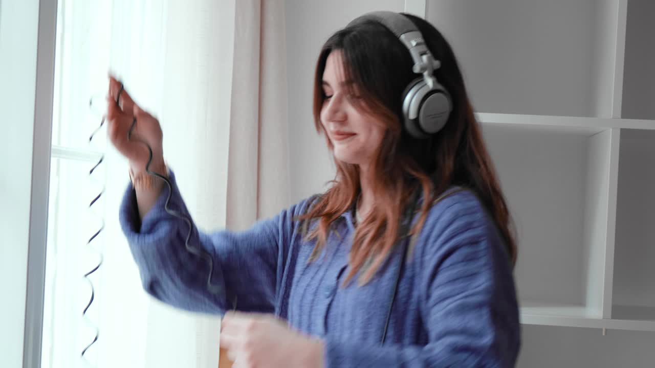 Young girl with headphones dances while listening to music