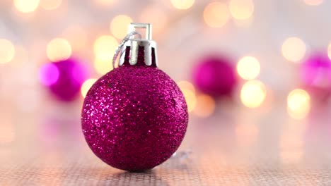 adornos de navidad rosados para el árbol de navidad en la mesa con luces parpadeantes