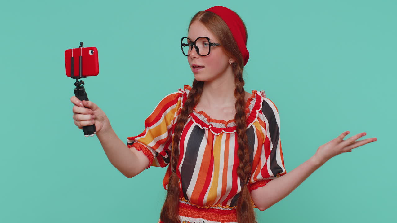 blogger chica tomar selfie en el teléfono móvil selfie stick comunicarse llamada de video en línea con los suscriptores