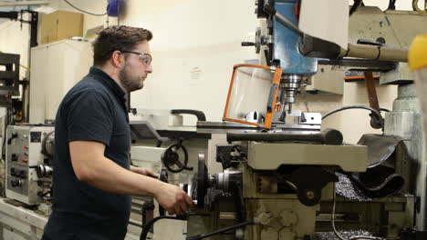 hombre que opera una máquina de fresado en un entorno industrial, centrado y dedicado a la metalurgia