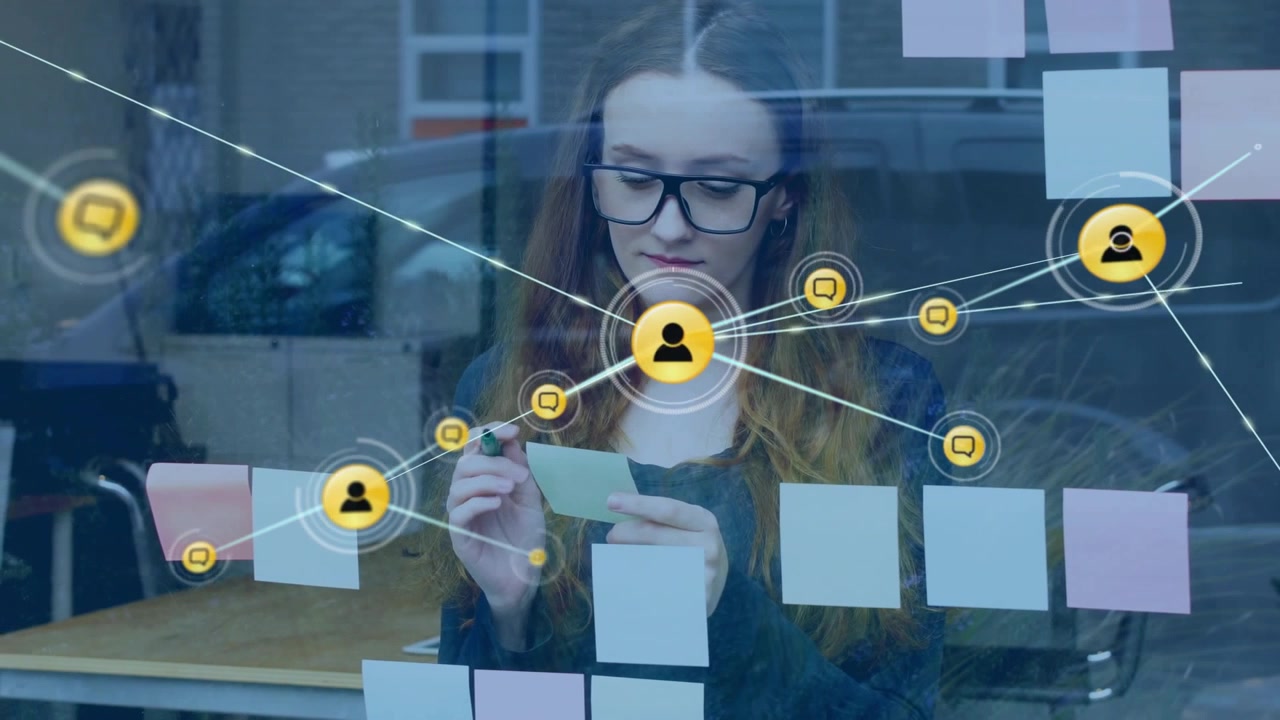 Planner reading sticky note and marking with green pen at glass while tech network icons spreading