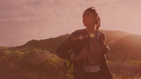 biracial woman with a backpack trying to catch a car on the road