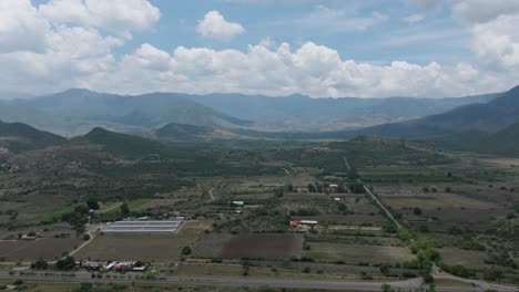 drone: dolly in shot of rural oaxaca, with mountains and cars passing by