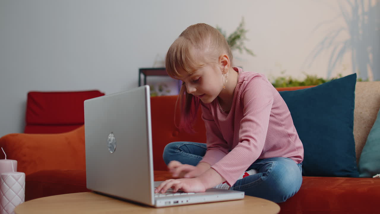 niña pequeña jugando con entusiasmo a un ordenador portátil un juego de simulador de tiro de realidad virtual en casa