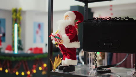 extreme close up shot of miniature santa claus toy used as christmas ornament in empty festive adorn fashion shop during winter holiday season. xmas decorations in shopping mall store