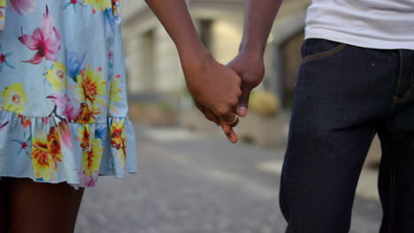 Unrecognizable-couple-having-date-outdoors.-Man-and-woman-holding-hands-in-city