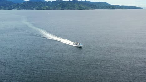 large white ferry boat transporting tourists from lombok to gili islands in bali indonesia, aerial