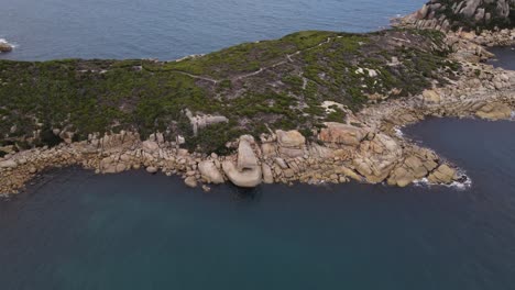 drone aerial slow pan and turn over beautiful blue water and green mountain on a sunny day in wilsons promontory