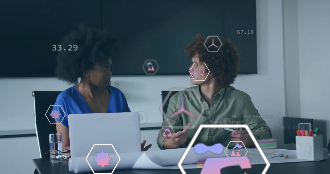 Woman leaning forward and gesturing at laptop, colleagues analyzing energy data with floating icons