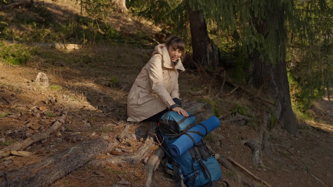 Woman resting with backpack in forest