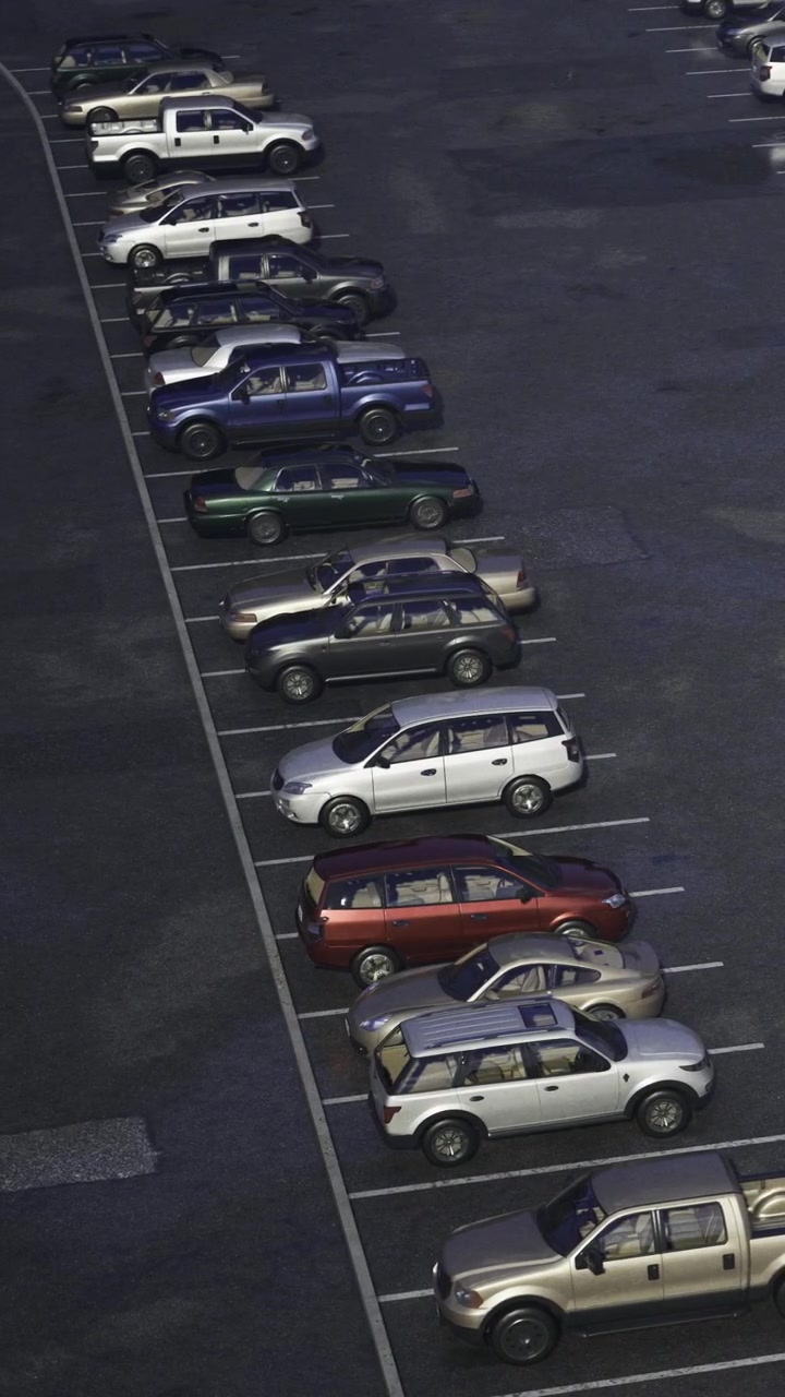 Biler parkeret på en parkeringsplads om natten i et byområde.