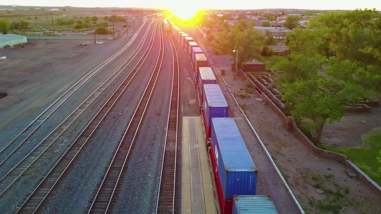 High aerial over a freight train full of containers for export heading into the sunset 1