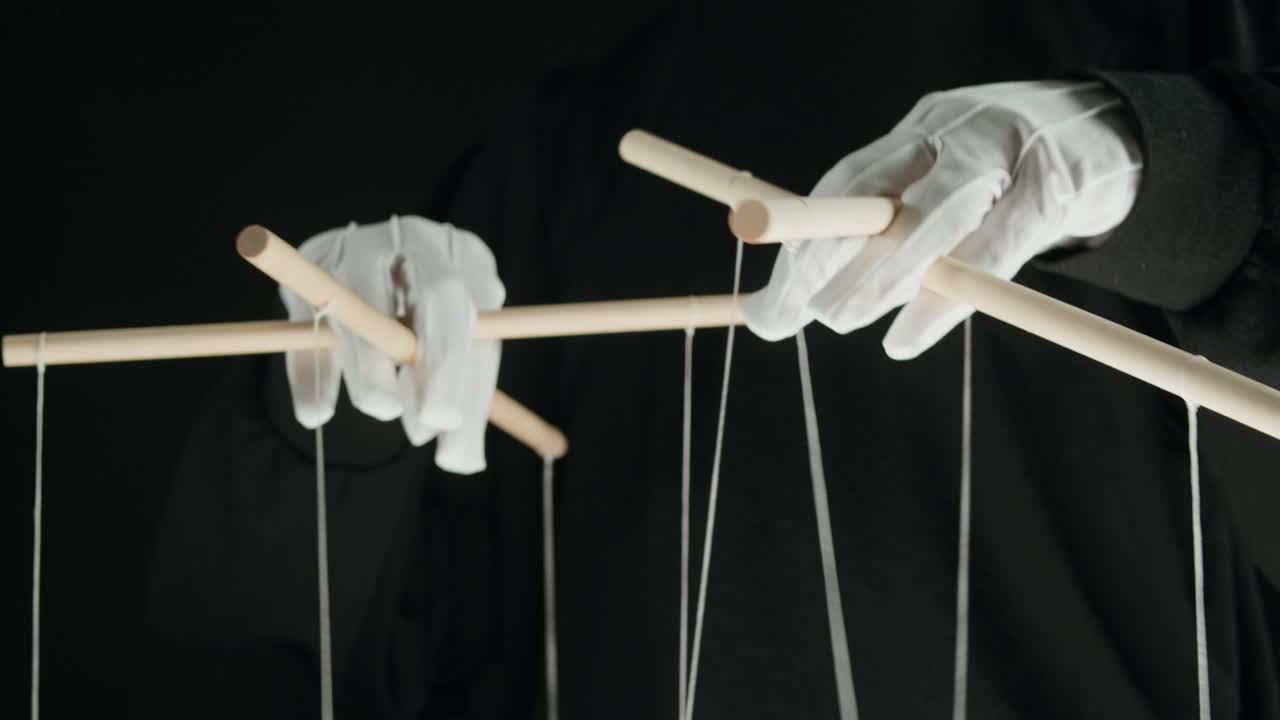 Hands in White Gloves Manipulating Puppet Controls