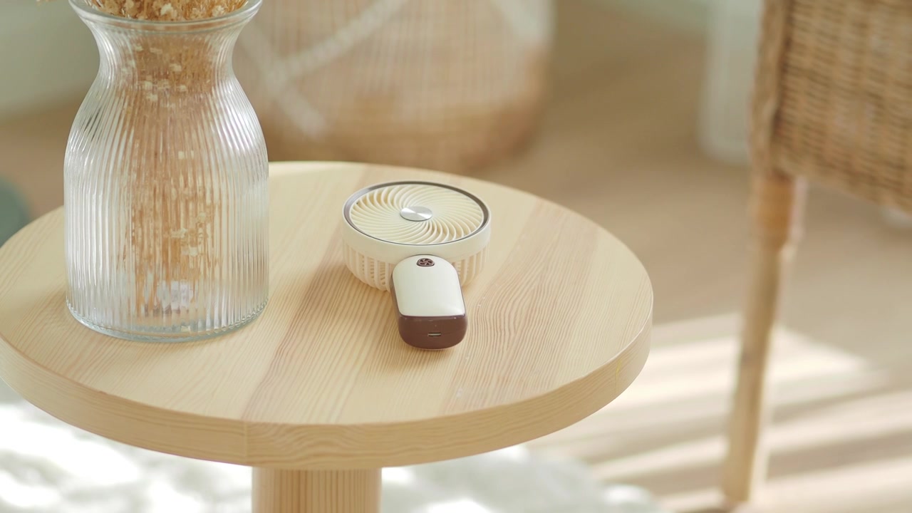 Small Portable Electric Fan Resting on a Wooden Table