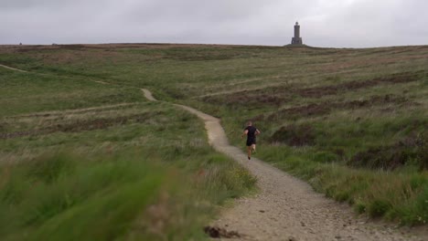 un joven corriendo por los páramos en darwen tower, lancashire