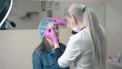 la cosmetóloga hace tatuajes de cejas en el salón a cámara lenta.