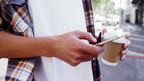 a man texting and drinking coffee