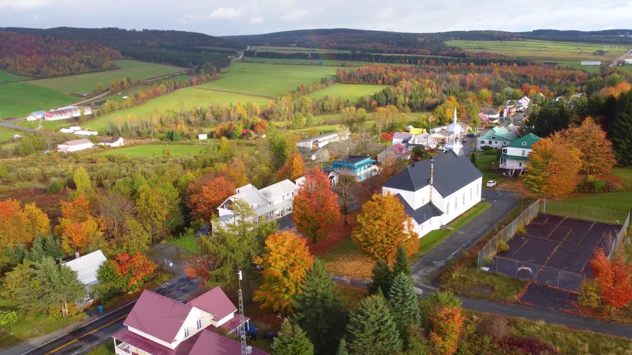 Orbit drone shot of typical Canadian town with autumn colors in region of Estrie, Quebec, Canada