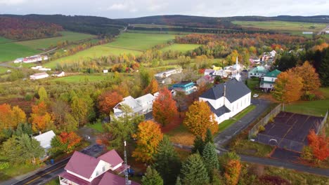 orbit drone shot of typical canadian town with autumn colors in region of estrie, quebec, canada