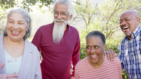 Happy-diverse-senior-female-and-male-friends-talking-and-laughing-in-sunny-garden,-slow-motion