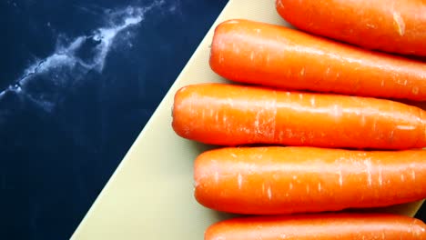 fresh carrots on chopping board on table