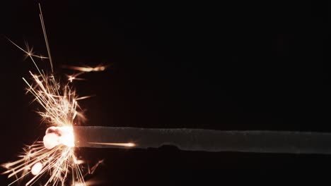 Video-of-close-up-of-sparkler-and-copy-space-on-black-background