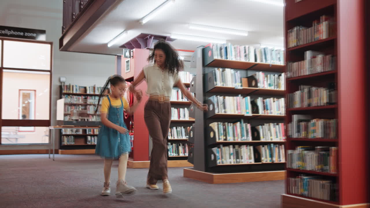 Happy Woman and Girl Skipping Playfully in a Library