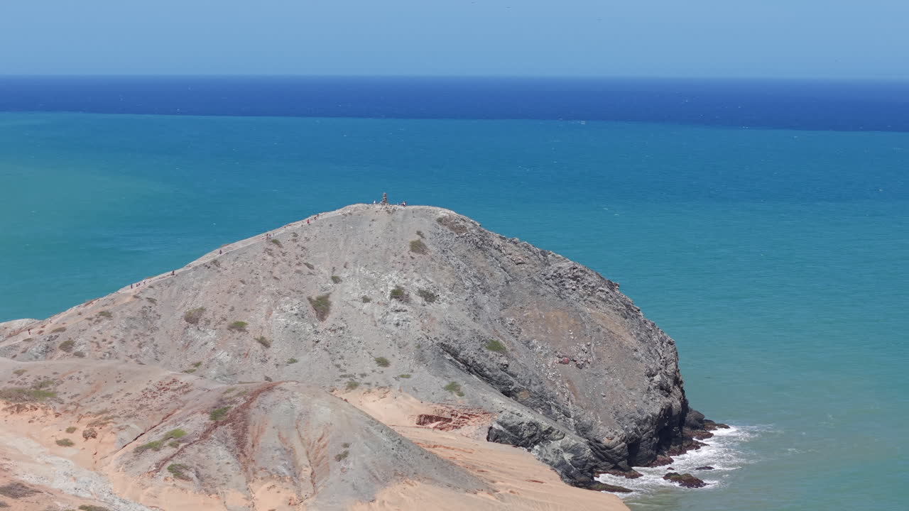 Dronekuvaa, joka tallentaa eloisan sinisen meren ja karun maiseman Pilon de Azucarin, Cabo de la Velan, Kolumbian ympärillä kirkkaana, aurinkoisena päivänä, esitellen luonnon kauneutta.