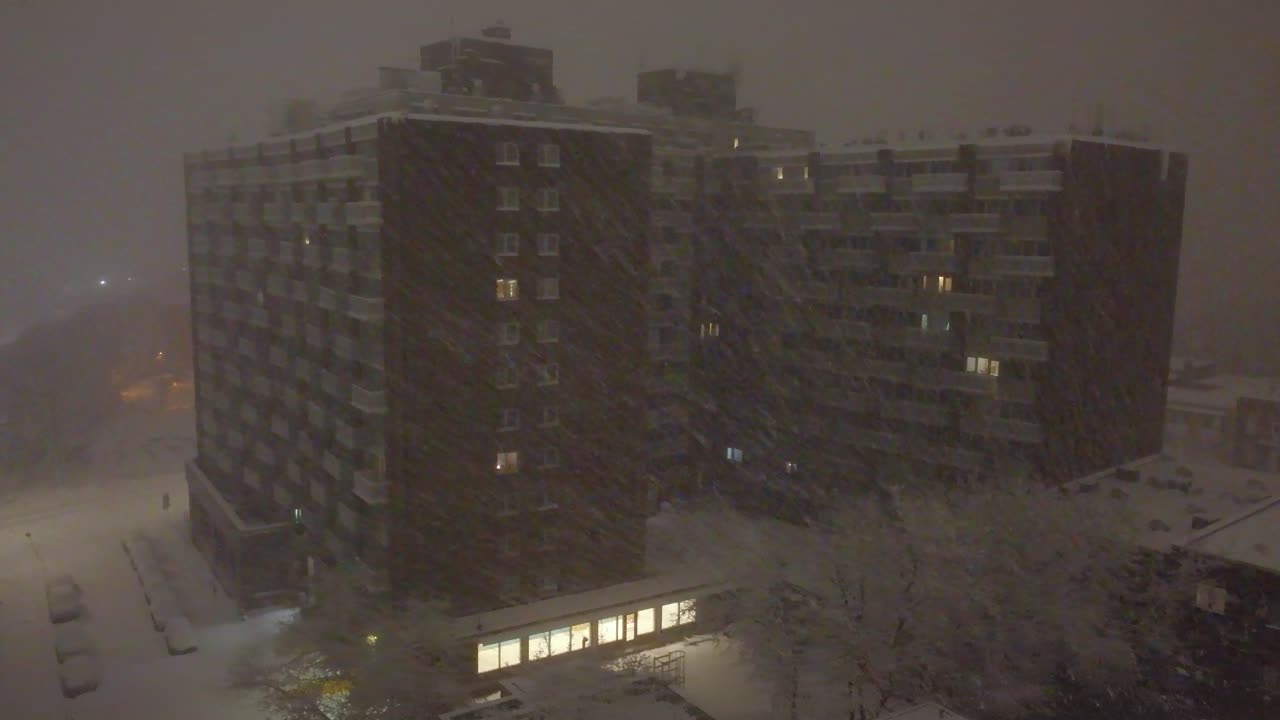 edificio de apartamentos de tormenta de invierno cubierto de nieve durante una fuerte nevada en montreal, canadá