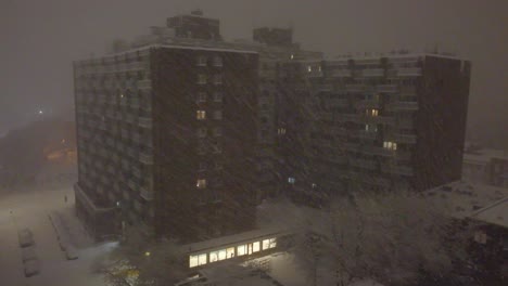 edificio de apartamentos de tormenta de invierno cubierto de nieve durante una fuerte nevada en montreal, canadá