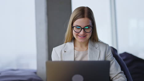 young business lady works at her laptop. business woman takes off her glasses and looks aside dreamily.