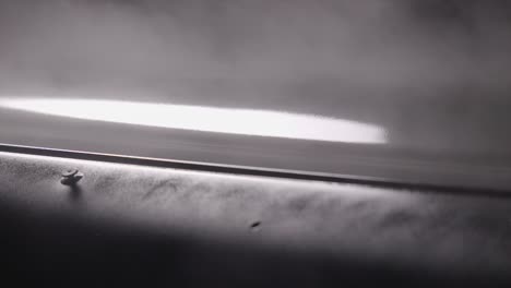 auto spray paint applied by compressor machine onto car bodywork close up