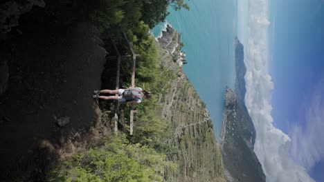 toma vertical de una viajera con mochila haciendo senderismo en la costa de amalfi en verano en italia