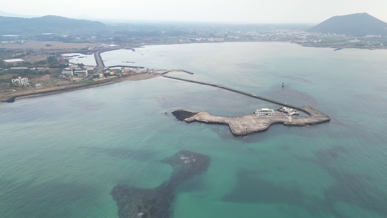Drone aerial view in South Korea countryside flying over the ocean and green island small village island jeju island cloudy