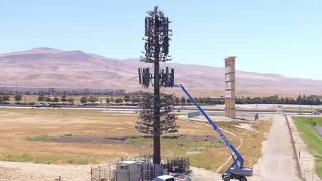 industrial crane scaled on a tall cell site during repair work in california, usa