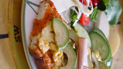 delicious avocado toast with ham and vegetables
