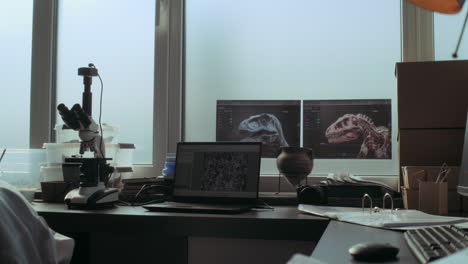 scientist's workstation with microscopes and dinosaurs