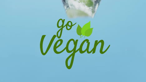 animation of go vegan text over fruit falling in water background