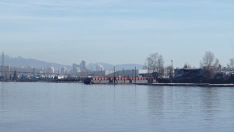 cityscape,-cars-passing-over-bridge-and-river-inlet-and-tankers-timelapse